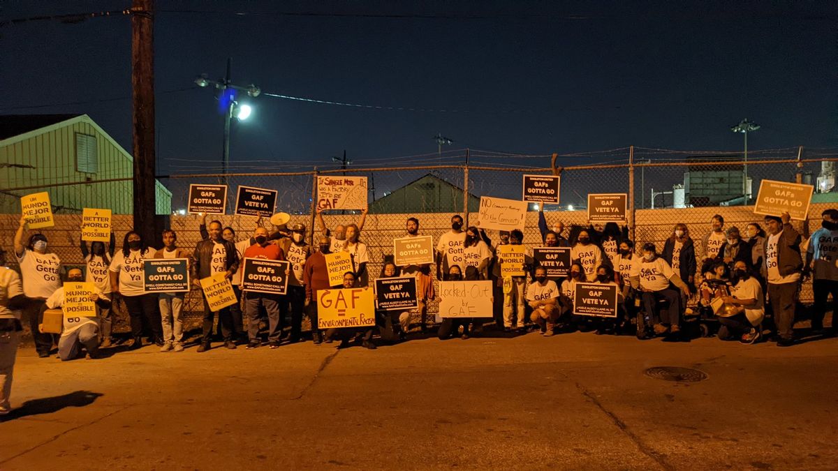 Neighborhood residents and supporters of GAFs Gotta Go Campaign pose with signs outside GAF facility